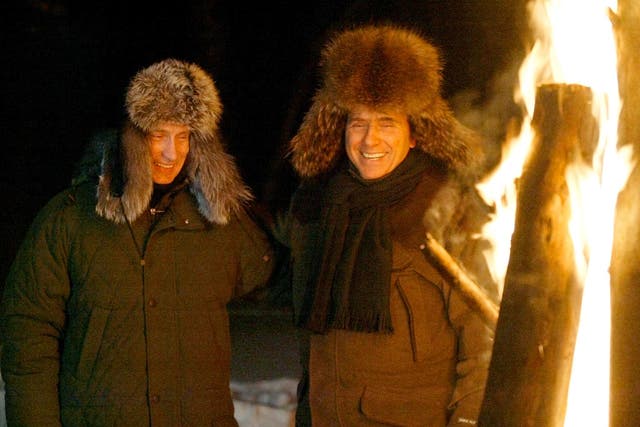 <p>Russian President Vladimir Putin and Italian Prime Minister Silvio Berlusconi smile as they stand near a huge fire in a wildlife preserve and recreation area near a residence of Zavidovo, north-west of Moscow in February, 2003</p>