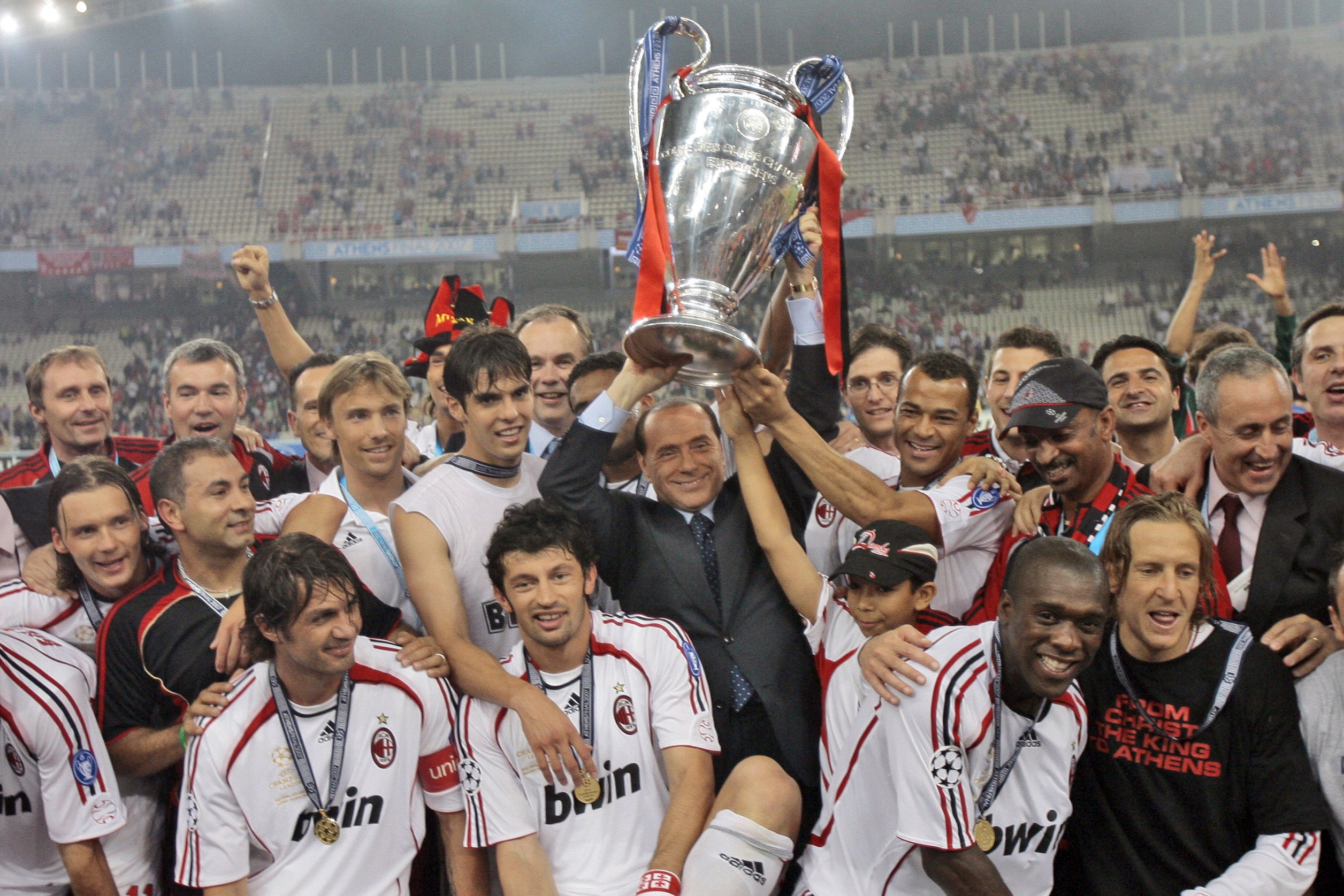 Berlusconi raises the Champions League trophy aloft alongside AC Milan players after they beat Liverpool 2-1 in the 2007 final