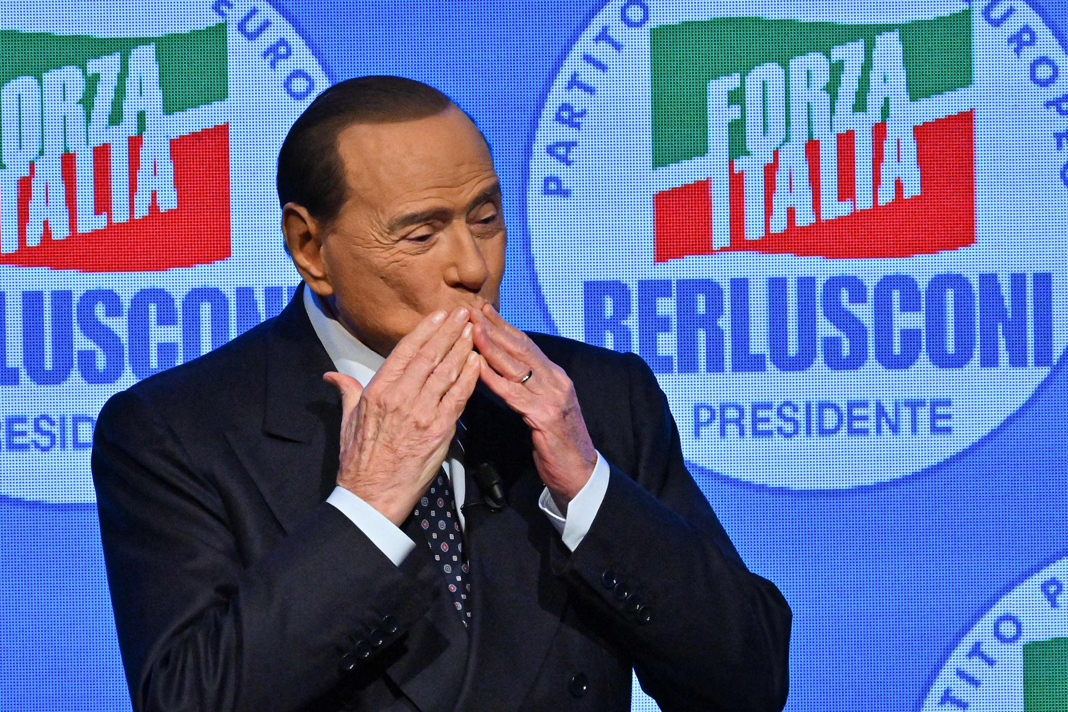 Silvio Berlusconi acknowledges applause on stage in Milan during a meeting at the close of Forza Italia’s campaign for the September general election in 2022