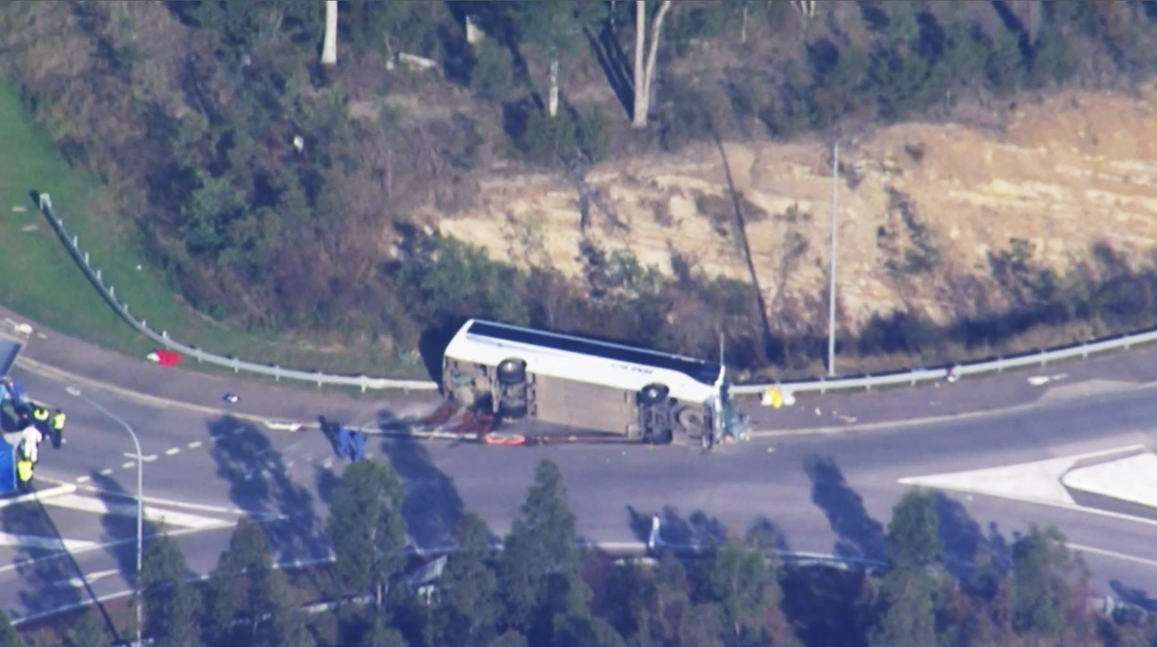 Image shows the overturned bus which killed 10 people as it crashed