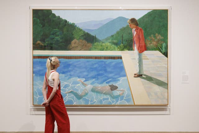 A person looks at David Hockney’s, Portrait of an Artist (Pool with Two Figures), 1972, during a photo call for London’s Tate Modern’s new Capturing the Moment exhibition, which includes works by Andy Warhol, Picasso and Francis Bacon. (Belinda Jiao/PA)