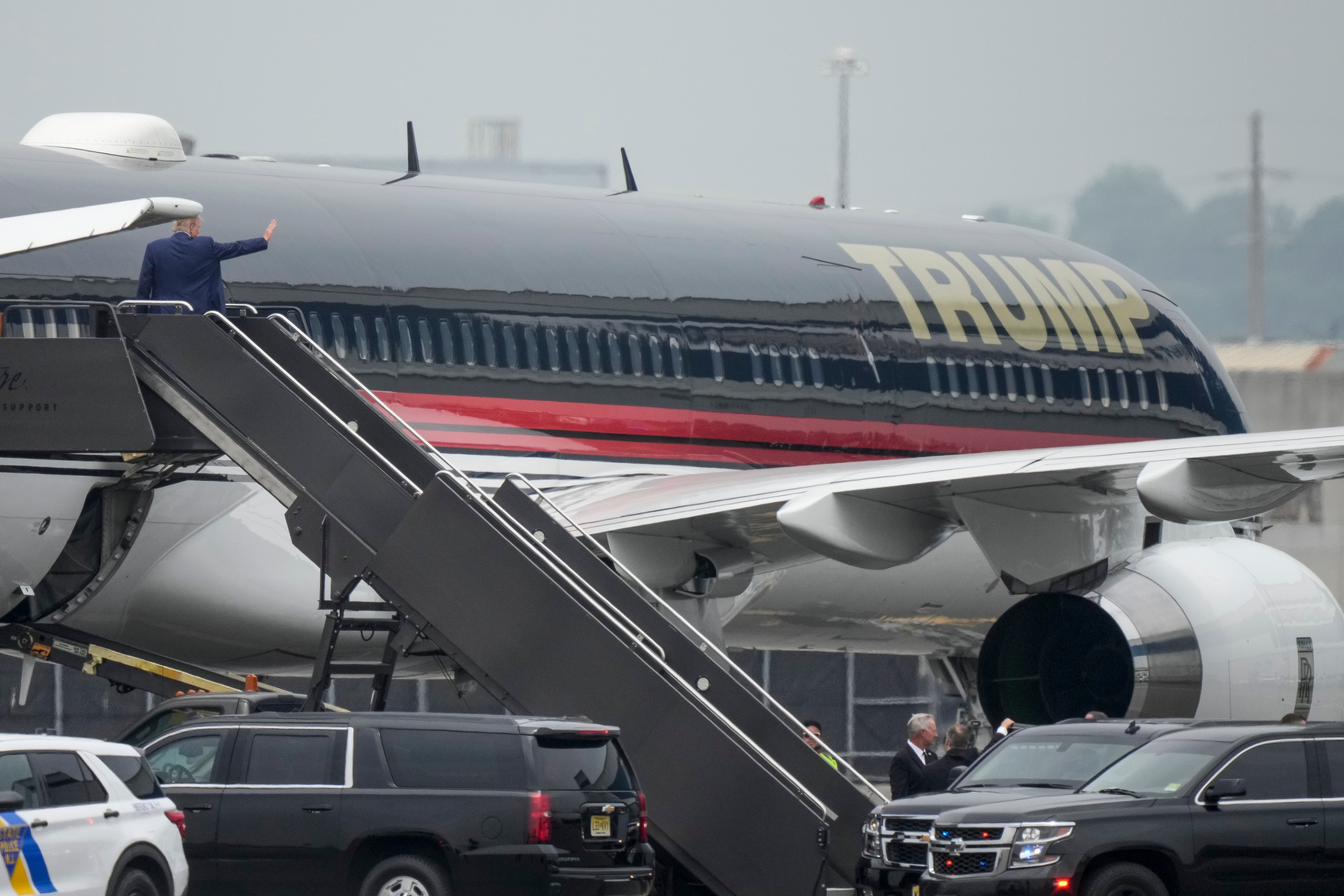 Trump waves as he boards his plane in New Jersey bound for Miami