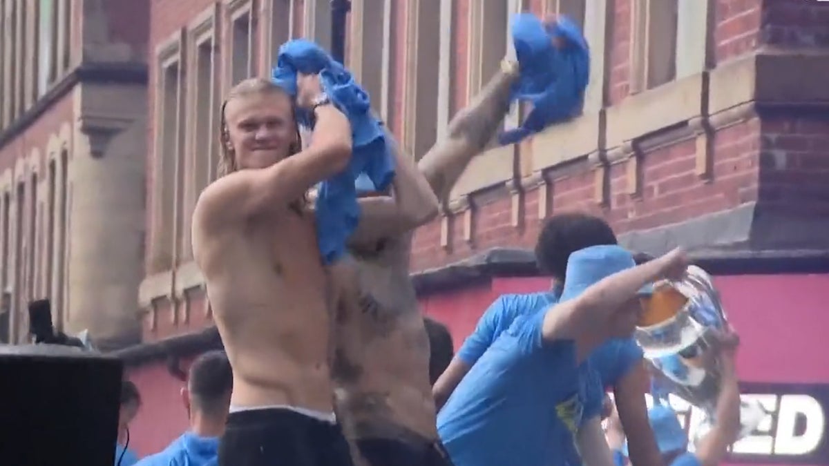 Manchester City players take top off during Champions League victory parade