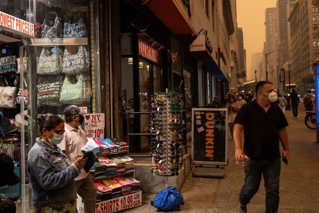 <p>A person sells face masks outside a souvenir store in New York City on Wednesday, June 7, 2023 after smoke from Canadian wildfires shrouded the city </p>