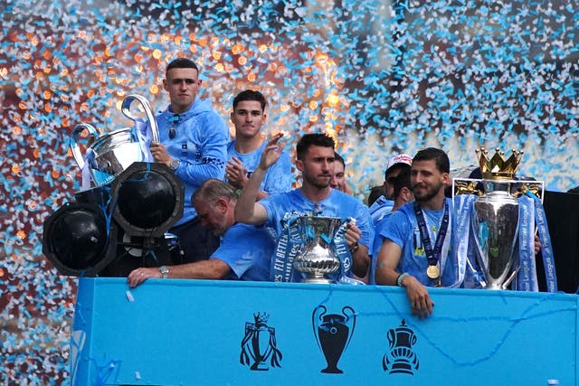 Manchester City’s players were flanked by thousands of fans as the team celebrated their treble triumph with an open-top bus parade (Peter Byrne/PA)