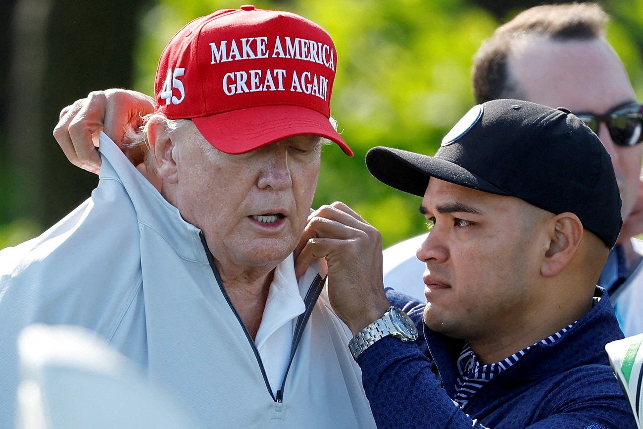 Nauta adjusts Trump’s collar at a LIV Golf Pro Am event in Virginia in May