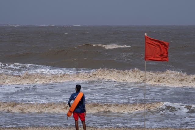 <p>A lifeguard stands during high tide at a deserted Juhu beach on the Arabian Sea cost in Mumbai, India on Tuesday, 13 June </p>