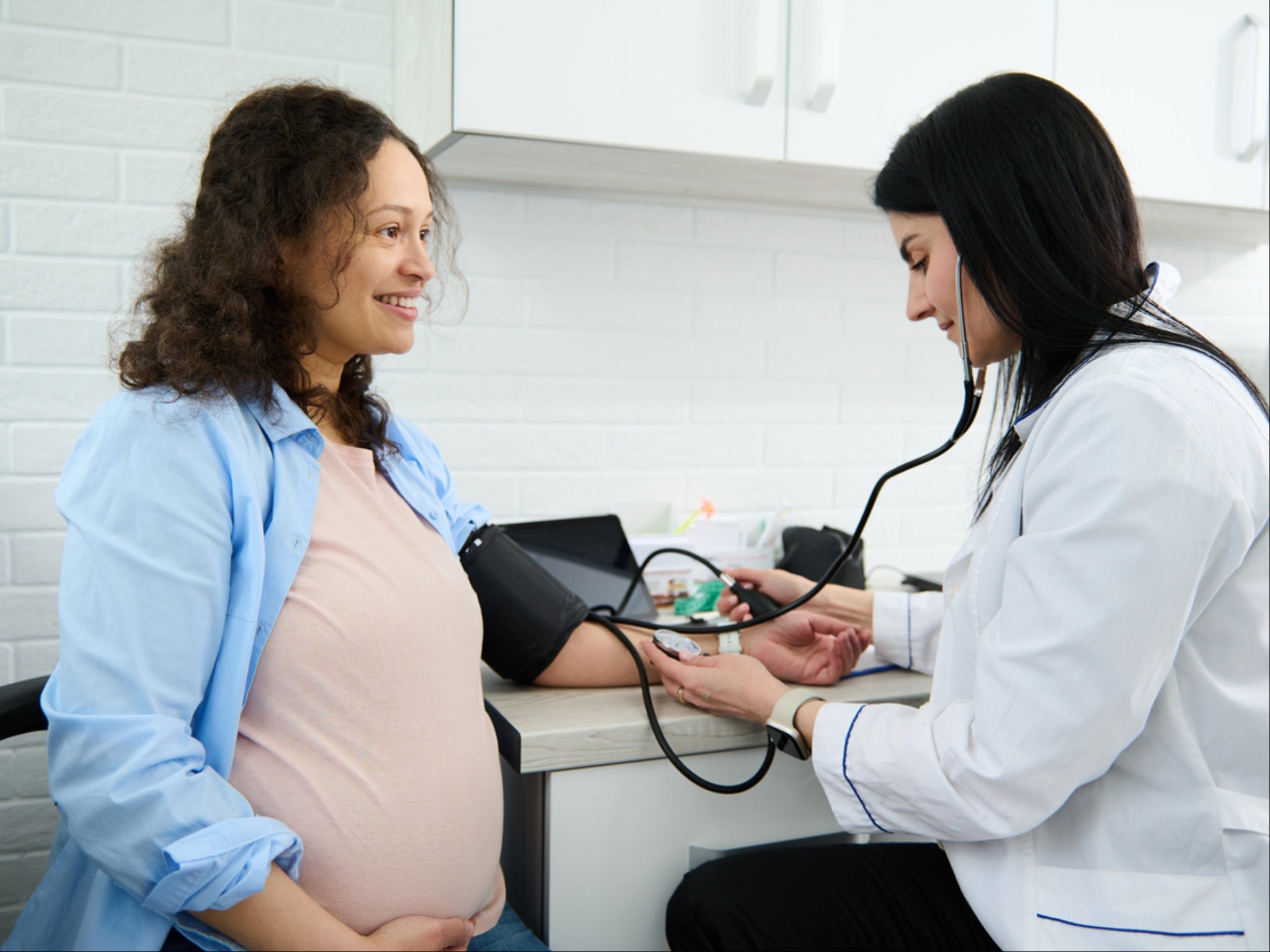 Obstetrician checks pregnant woman’s blood pressure