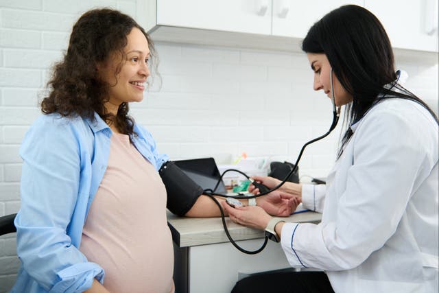 <p>Obstetrician checks pregnant woman’s blood pressure </p>