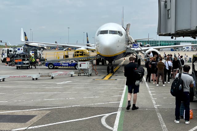 <p>On the move: boarding a Ryanair plane at London Stansted airport </p>