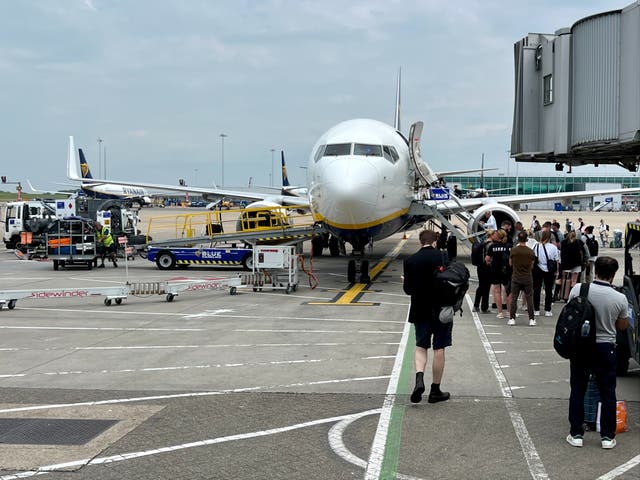 <p>On the move: boarding a Ryanair plane at London Stansted while flights were being grounded at Gatwick and Heathrow</p>