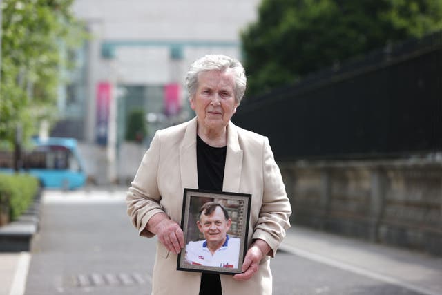 Bridie Brown, the widow of murdered GAA official Sean Brown, holds a picture of him, outside the Royal Courts of Justice in Belfast (Liam McBurney/PA)