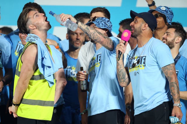 Manchester City’s Jack Grealish (left), Kalvin Phillips (centre) and Kyle Walker (right) on stage during the treble parade in Manchester (Nigel French/PA)