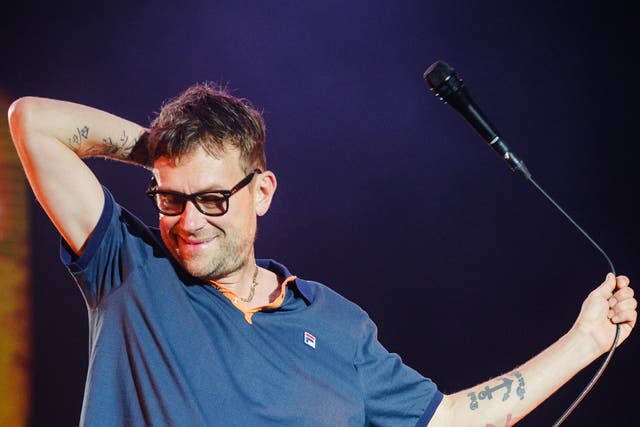 <p>Blur’s Damon Albarn does his best to bring some energy back into the arena after a downpour </p>