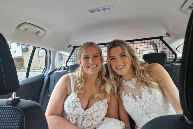 Sian and Jemma Batchelor-Thomas hitched a lift to their wedding in a police car after their coach broke down (Hampshire and Isle of Wight Constabulary/PA)
