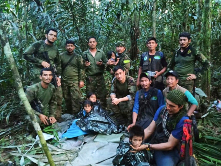 Army officers stand next to four children rescued after spending forty days in the Amazon Rainforest following a crash that killed their mother and two other adults