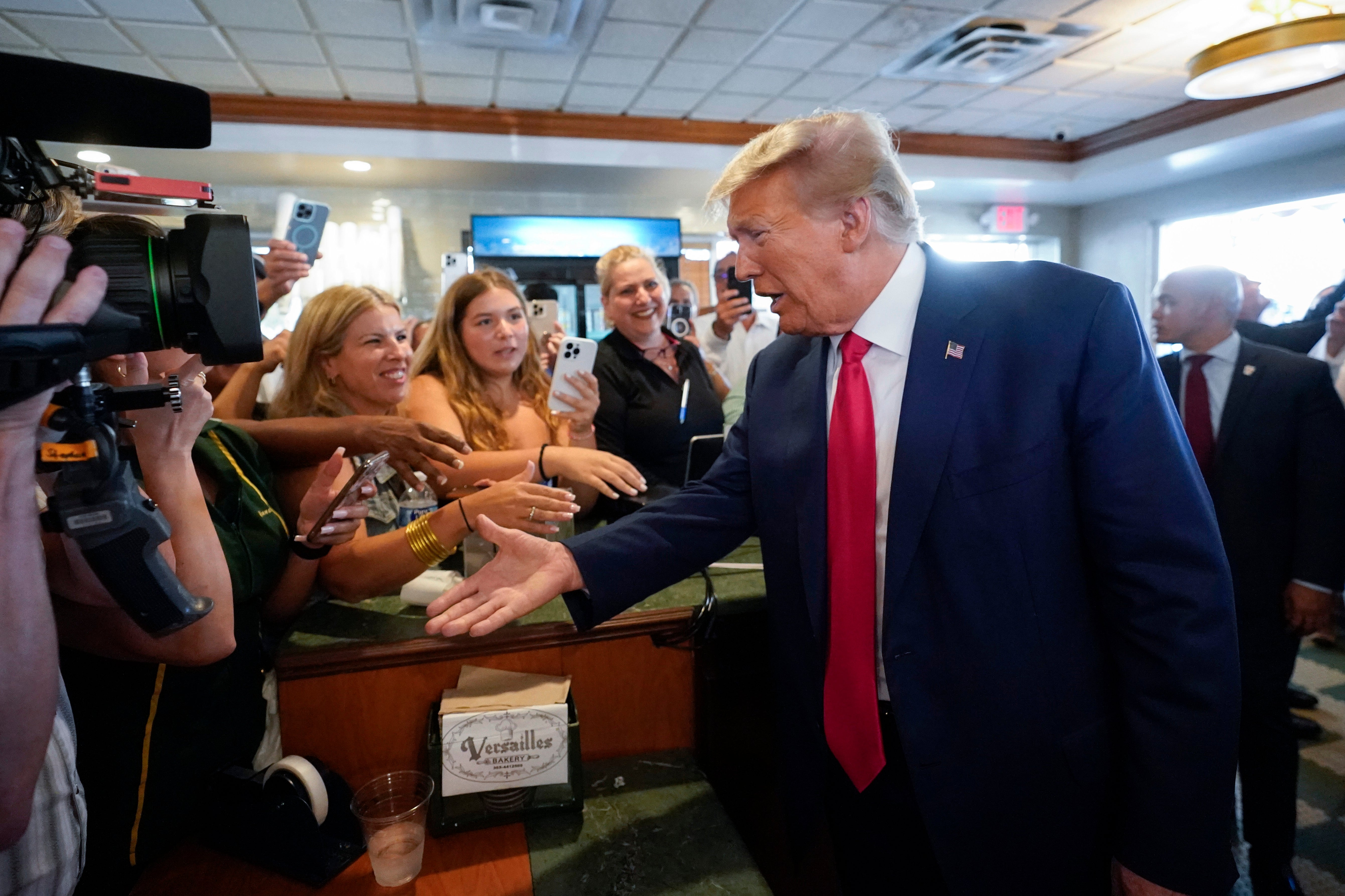 Trump greets supporters in a cafe in Miami following his arraignment