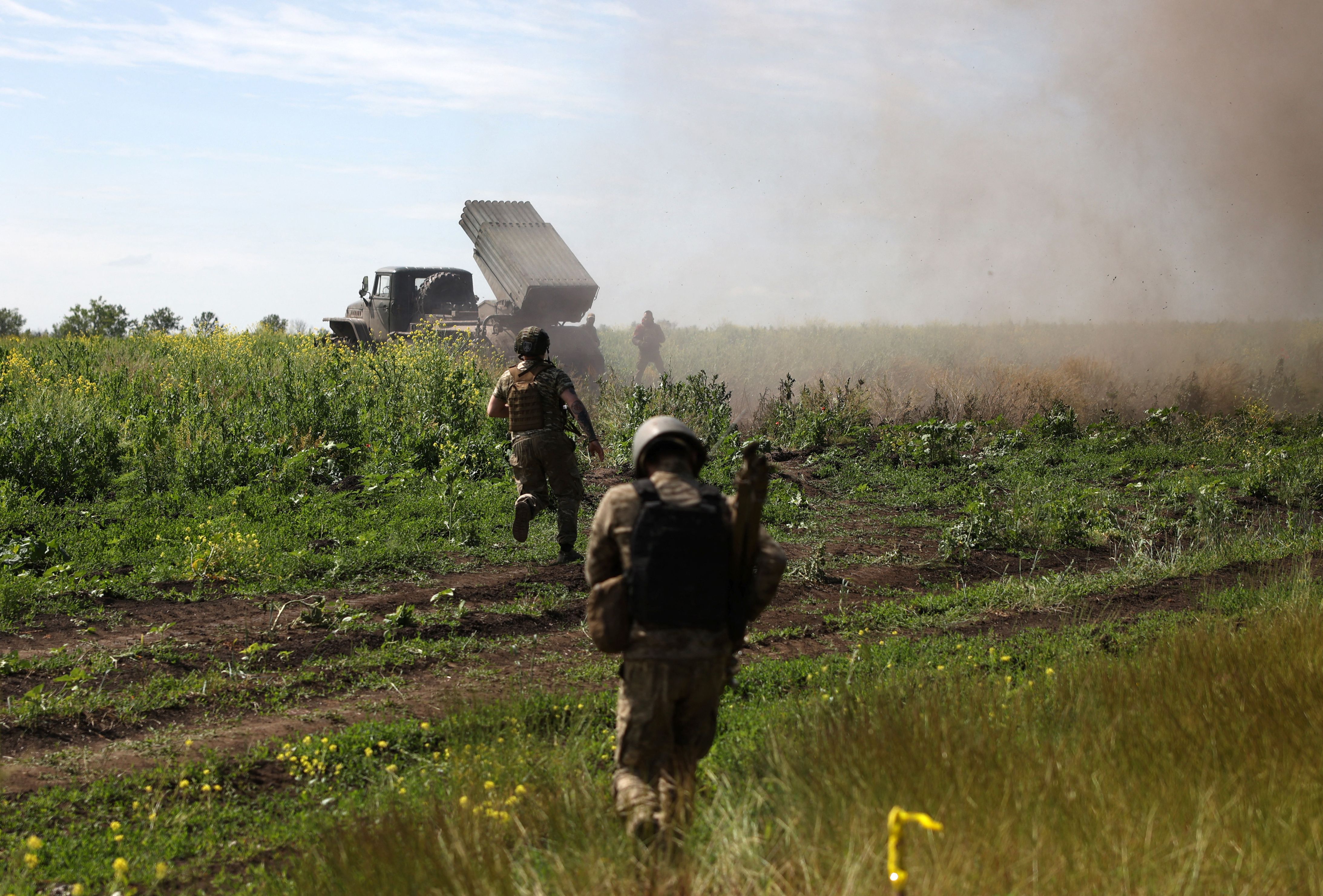 Ukrainian servicemen shift position after firing rockets from a BM-21 ‘Grad’ multiple rocket launcher towards Russian positions, near Bakhmut in the Donetsk region