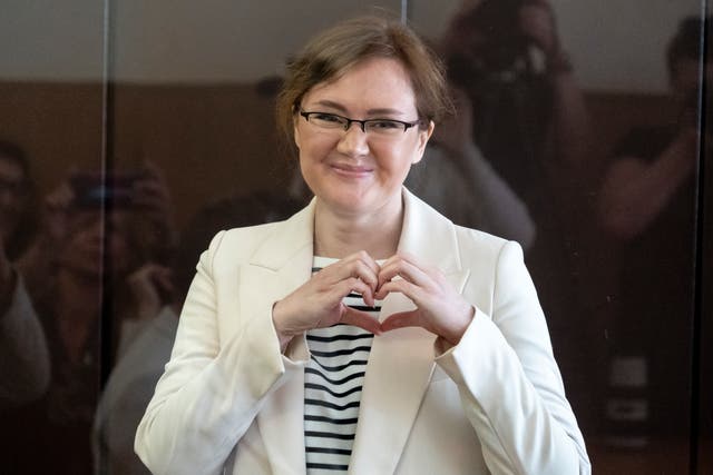 <p>Lilia Chanysheva makes a heart gesture as she is standing in a cage during the court hearing </p>