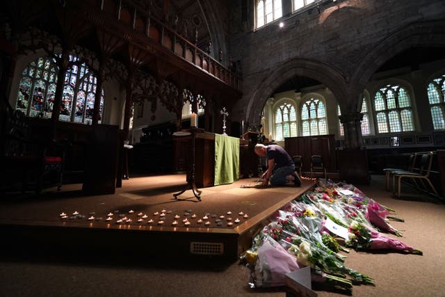 A person lighting a candle in St Peter’s church, Nottingham, in memory of the victims of the attack (Jacob King/PA)