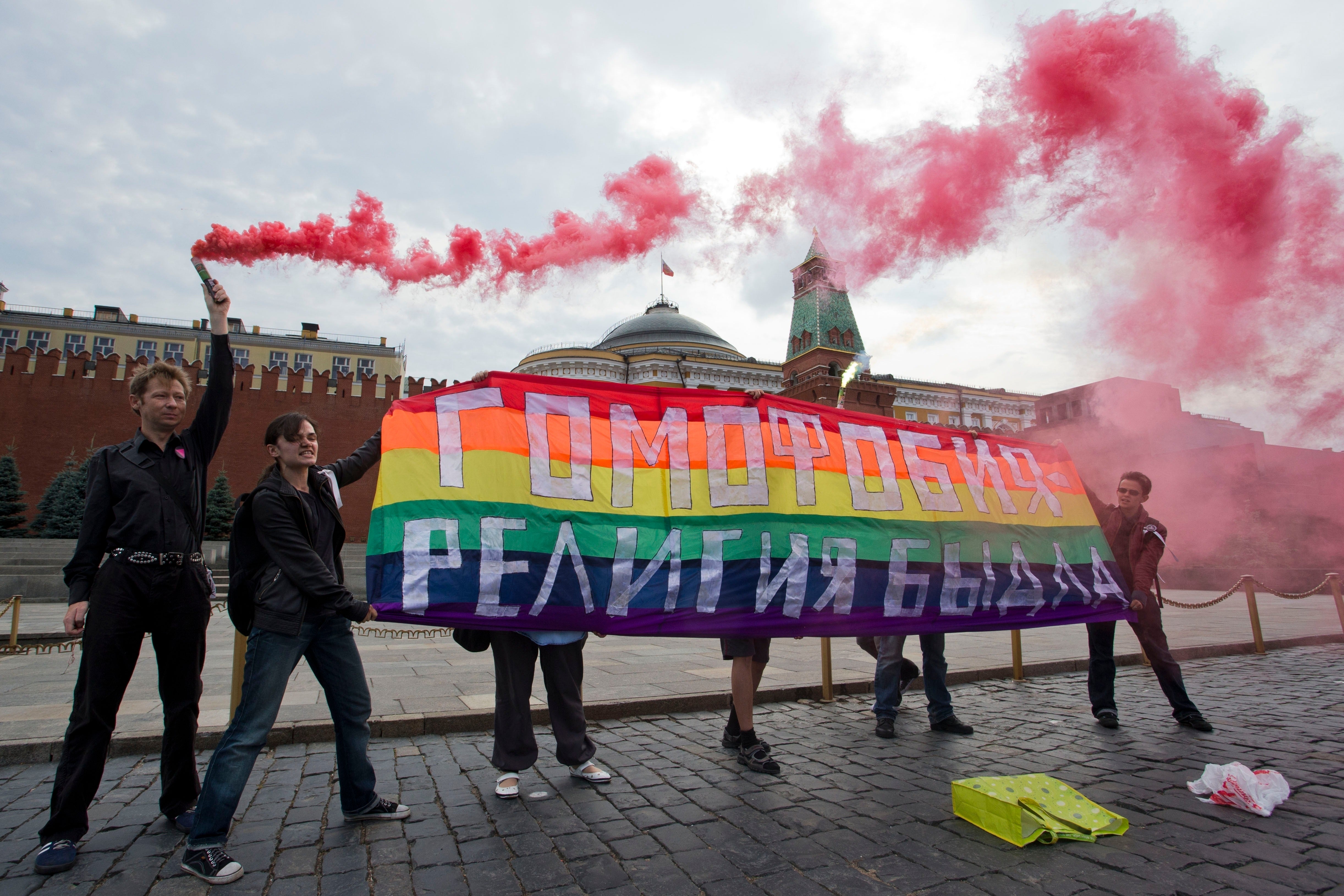Gay rights activists hold a banner reading ‘Homophobia - the religion of bullies’ during their action in protest at homophobia, on Red Square in Moscow, Russia, on July 14, 2013
