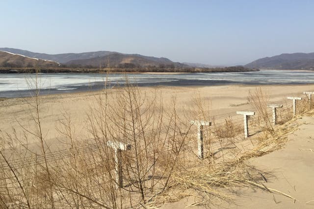 <p>A barbed-wire fence separating North Korea from China is seen in this photo taken from the Chinese border city of Hunchun</p>