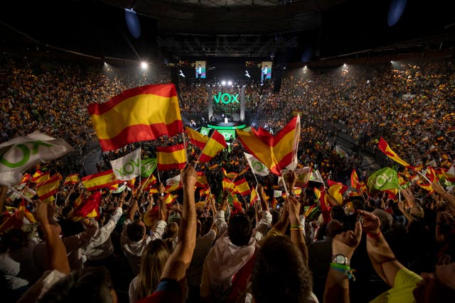 <p>Supporters wave flags as the leader of far-right party Vox, Santiago Abascal, makes a speech in Madrid </p>