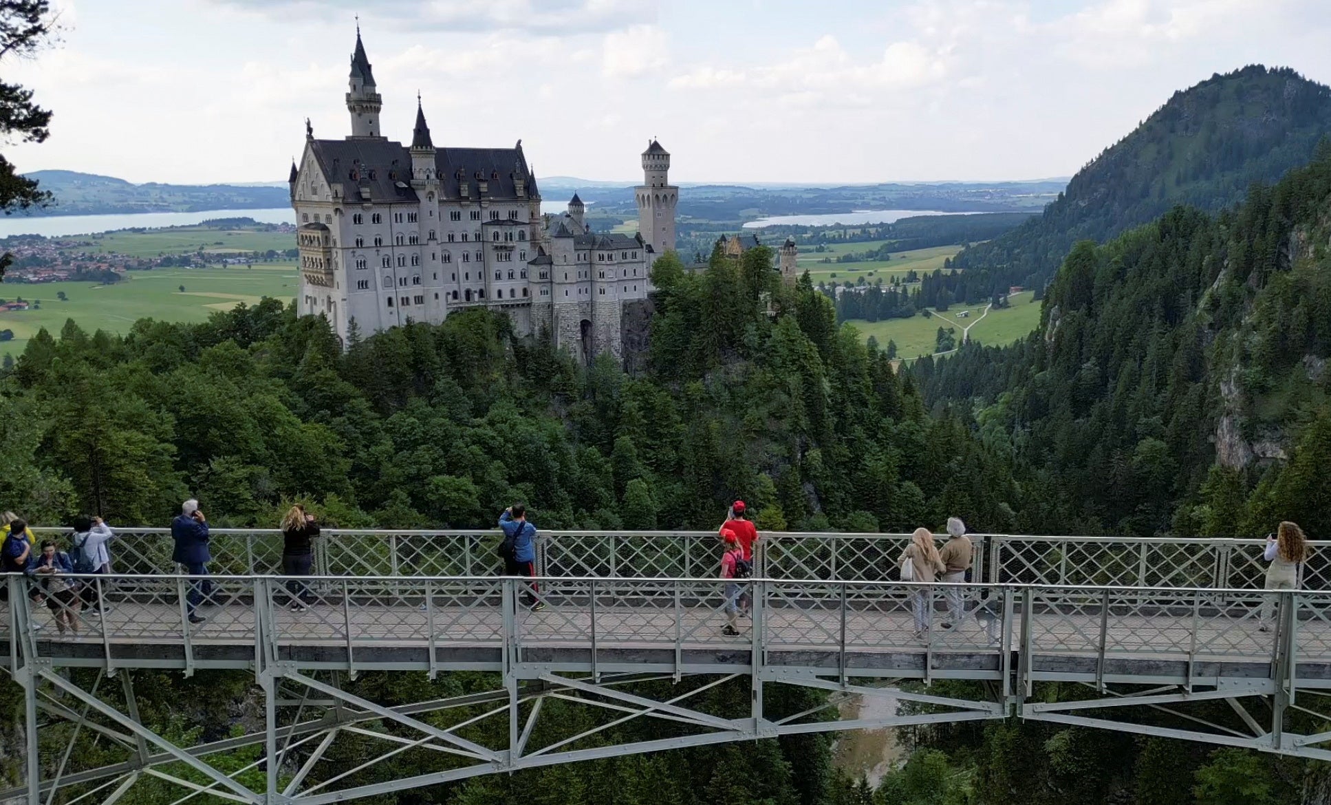 Tourists on the Marienbrücke bridge overlooking Neuschwanstein Castle