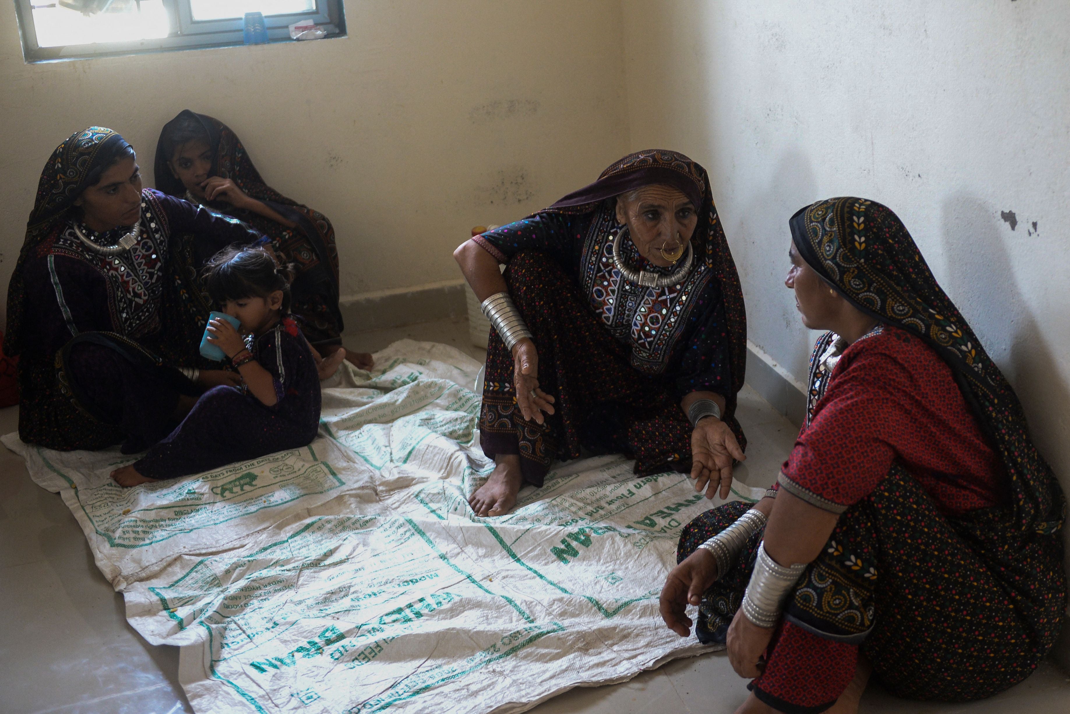 Women huddle around in a temporary shelter set at a health centre in Gujarat’s Jakhau village in Kutch district