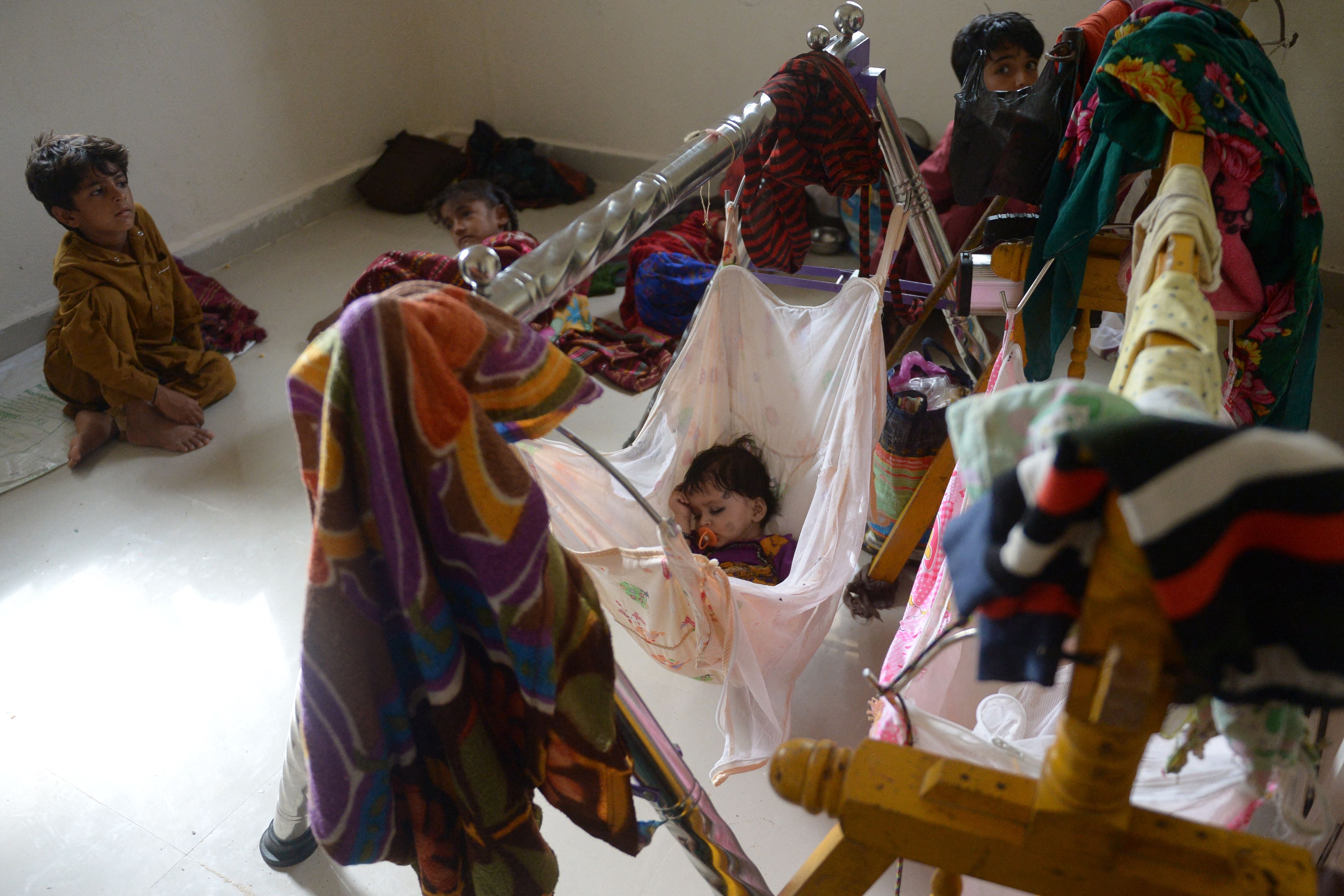 Children rest in a temporary shelter set at a primary health centre in Jakhau village of Kutch district in Gujarat