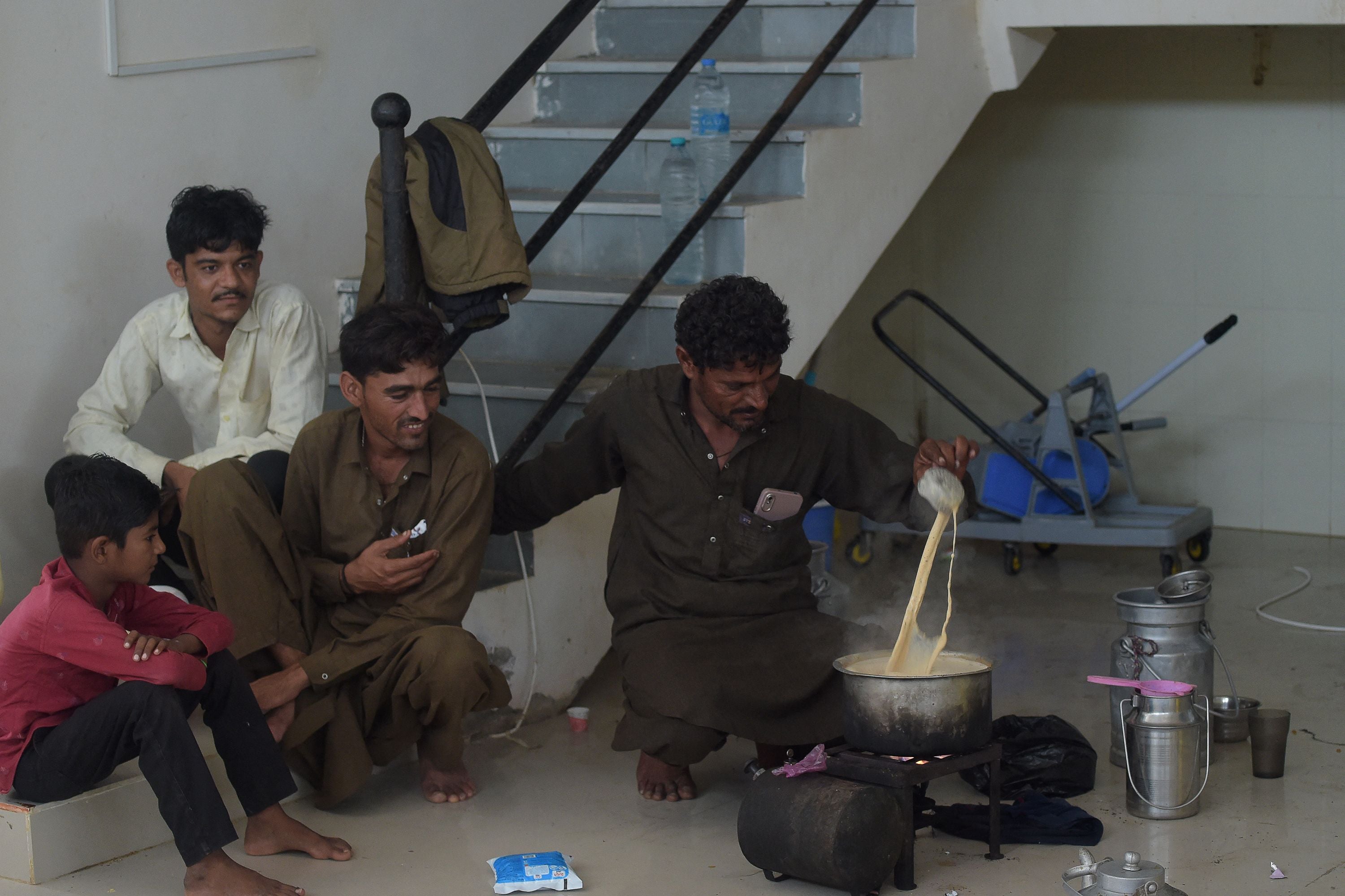 Residents make tea in a temporary shelter set at a primary health centre in Jakhau village of Kutch district in Gujarat state ahead of cyclone Biparjoy landfal