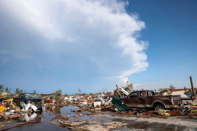 <p>Damaged pickup trucks sit among debris after a tornado tore through a residential area in Perryton, Texas on Thursday </p>