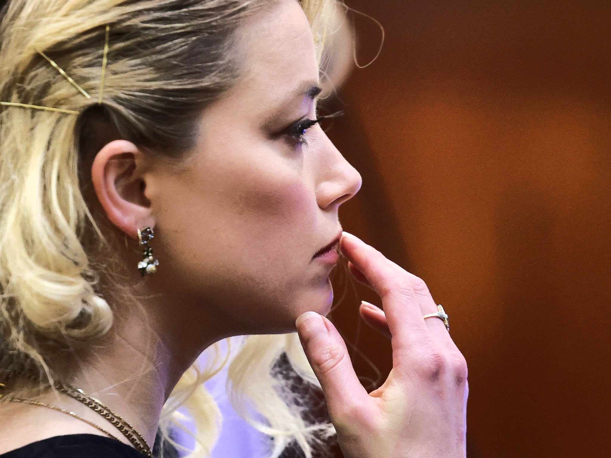 Meaningful or meaningless? Amber Heard touches her upper lip during her civil defamation trial in Virginia in June 2022