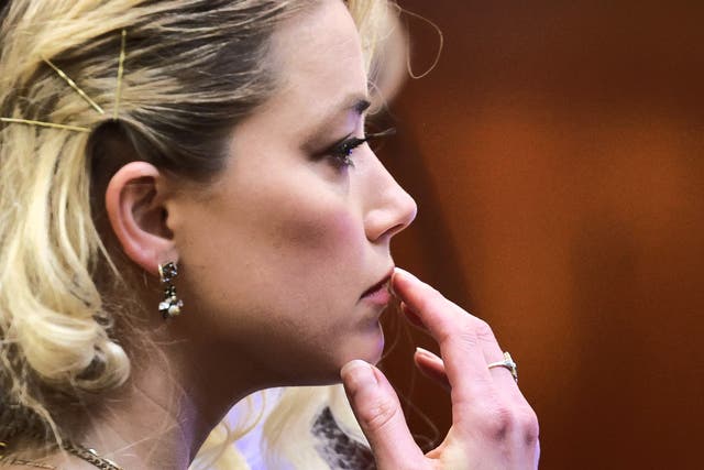<p>Meaningful or meaningless? Amber Heard touches her upper lip during her civil defamation trial in Virginia in June 2022</p>