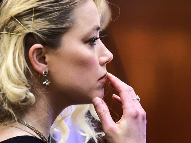 <p>Meaningful or meaningless? Amber Heard touches her upper lip during her civil defamation trial in Virginia in June 2022</p>
