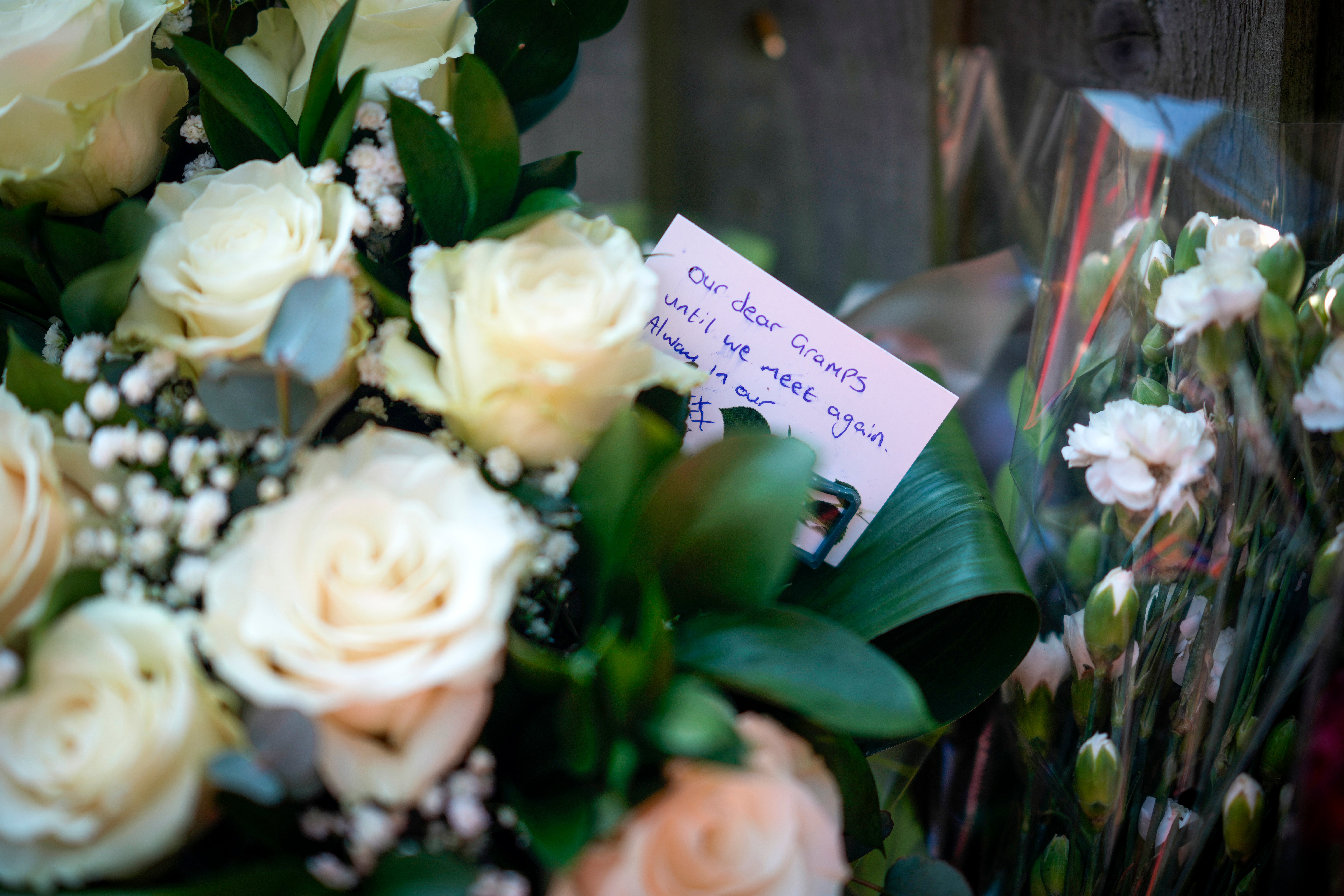 Flowers, tributes and messages adorn the scene in Magdala Road where school caretaker Mr Coates, 65, was found fatally stabbed