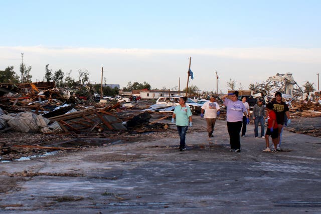 <p>People survey the damage as cleanup efforts continue on Friday in Perryton, Texas</p>