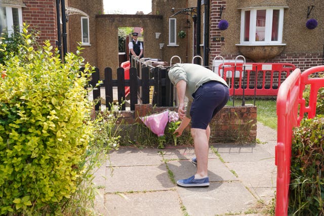 <p>A man lays flowers outside the duplex where the family lived </p>