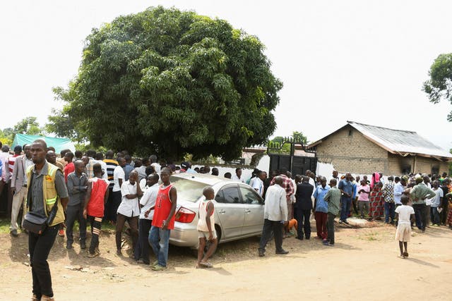 <p>Families wait for news outside the school in Mpondwe </p>