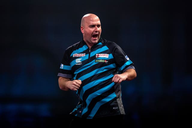 Rob Cross (pictured) and Michael Smith eased past Latvia to book their place in the World Cup of Darts quarter-final (Steven Paston/PA)
