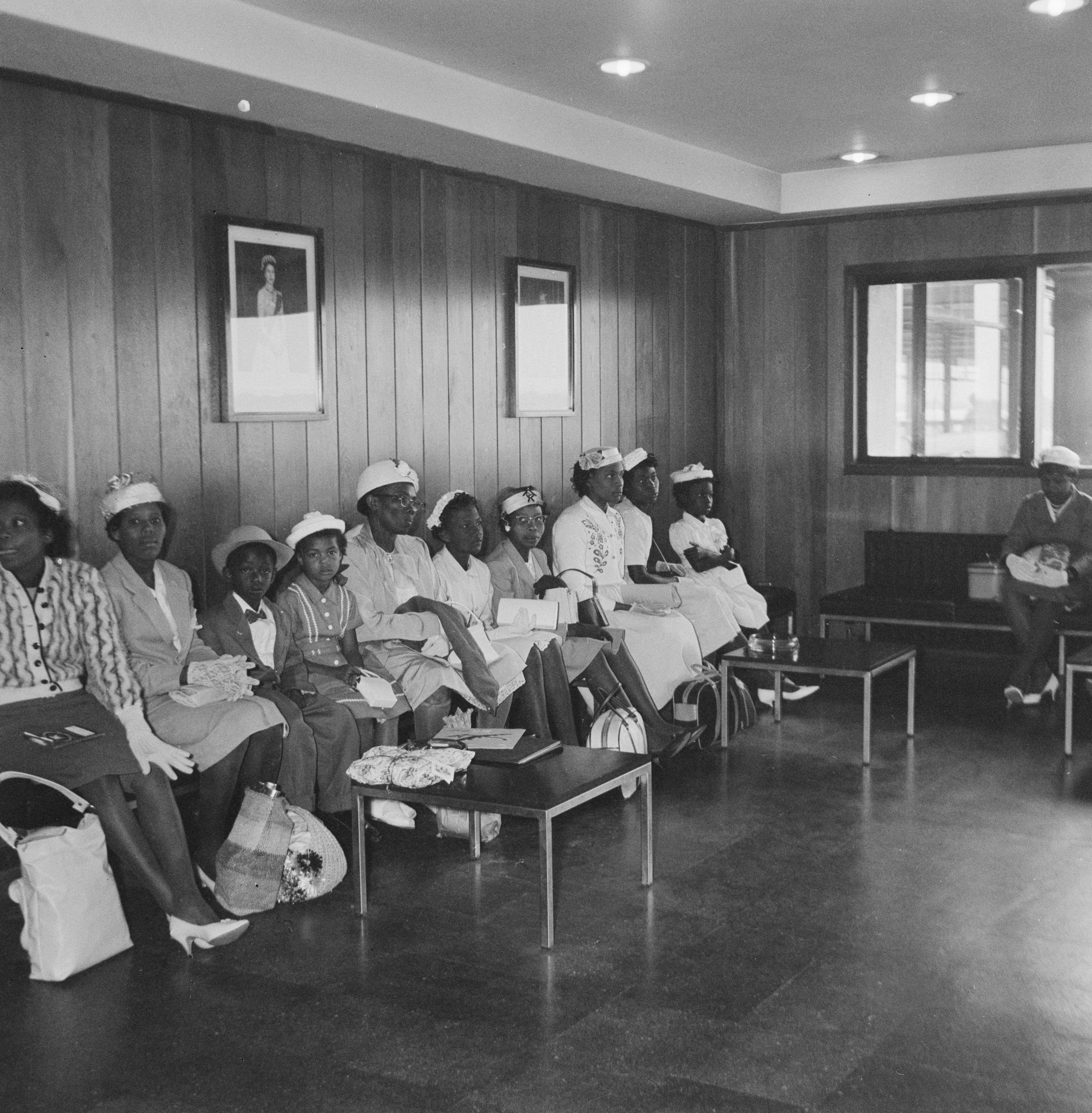 A group of women and children in a waiting room of an unspecified airport after getting off a plane coming from the Caribbean