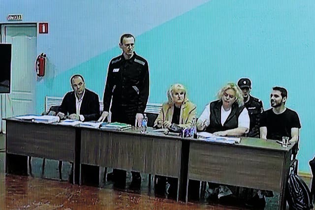 <p>Alexei Navalny, standing, with his lawyers during the hearing at Moscow City Court</p>