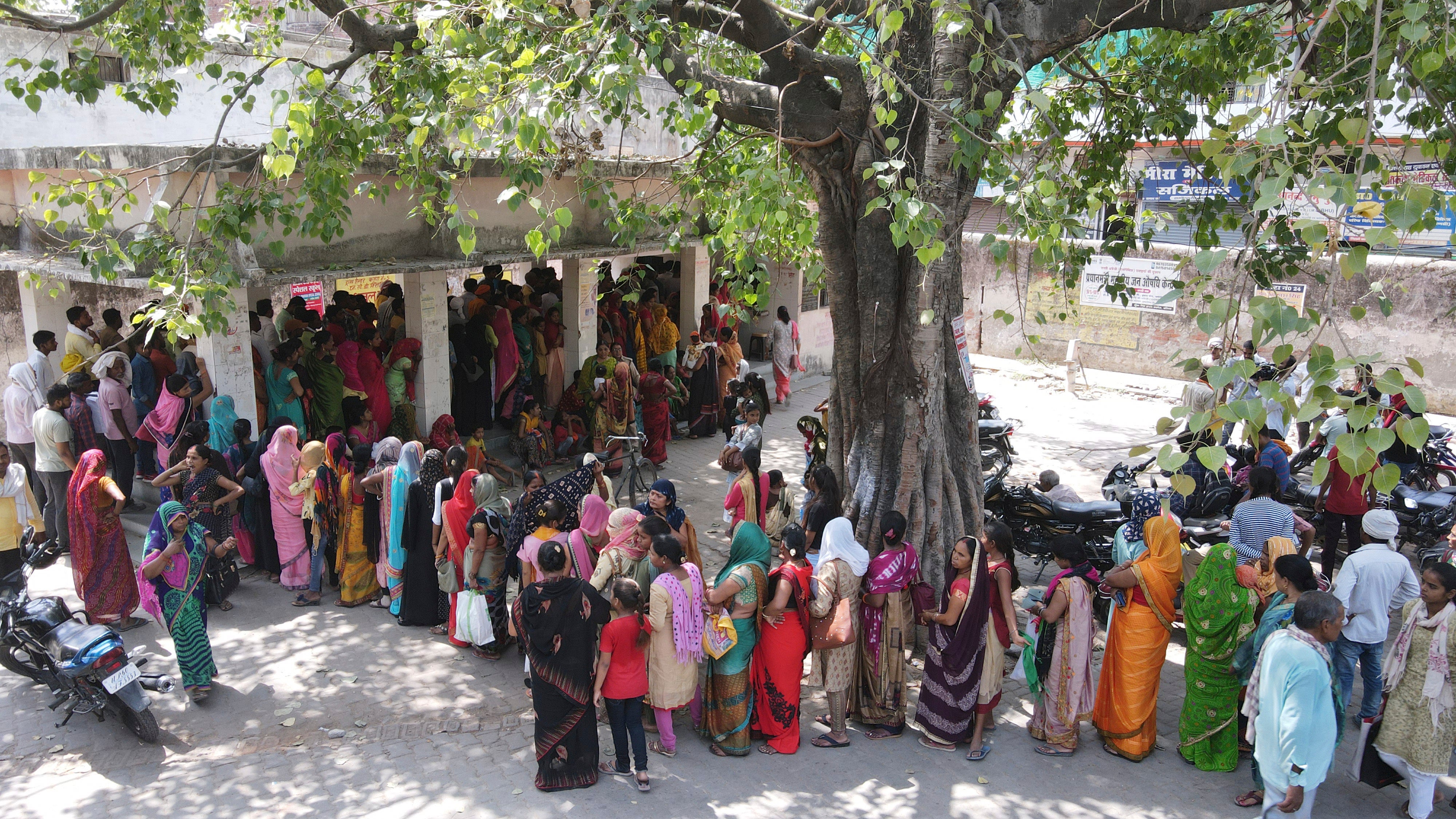 People stand in queue to register outside district hospital in Ballia, Uttar Pradesh state in India on a hot day in June amid a deadly heatwave