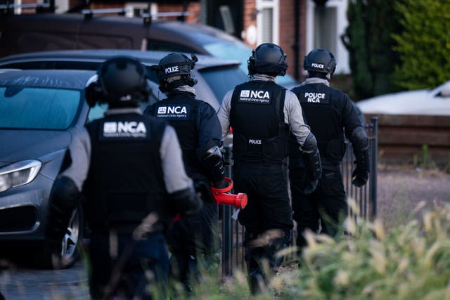NCA officers during one of the raids in Essex on Monday (Aaron Chown/PA)