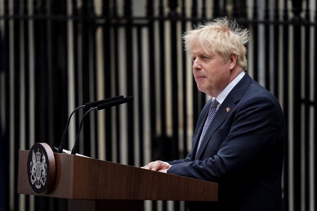 Prime Minister Boris Johnson, watched by wife Carrie Johnson (centre holding daughter Romy), reads a statement outside 10 Downing Street, London, formally resigning as Conservative Party leader (Gareth Fuller/PA)