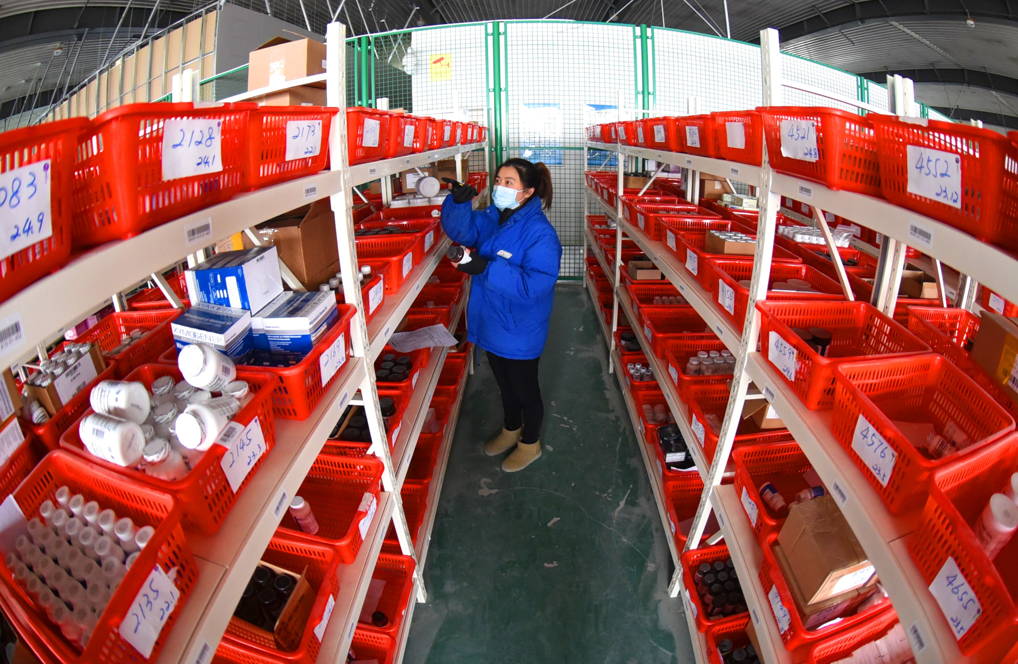 An employee arranges packages at a warehouse in a cross-border e-commerce industrial park in Lianyungang, Jiangsu province, in February 2023