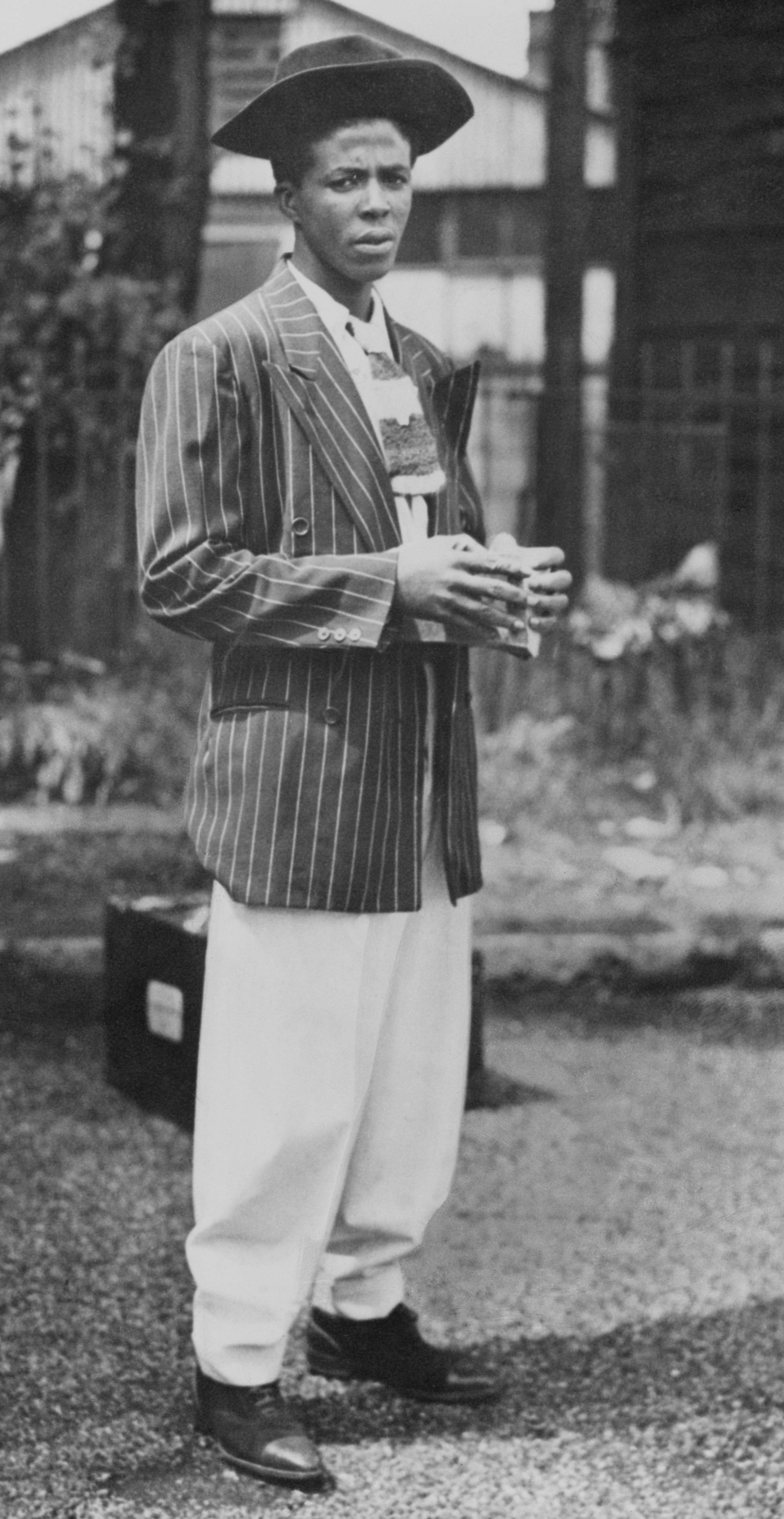 Mr W 'William' Dickson, wearing a 'zoot suit' as he steps ashore after arriving onboard the Empire Windrush