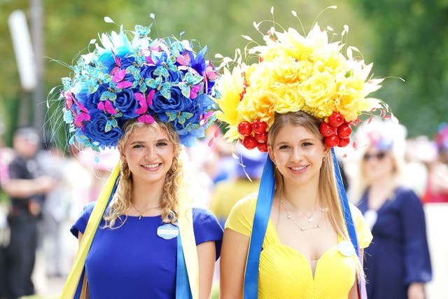 Anastasia Tutus (left) and Olena Sytnychenko pose for photographs while dressed in the colours of the Ukraine national flag during day one of Royal Ascot at Ascot Racecourse, Berkshire (Jonathan Brady/PA)