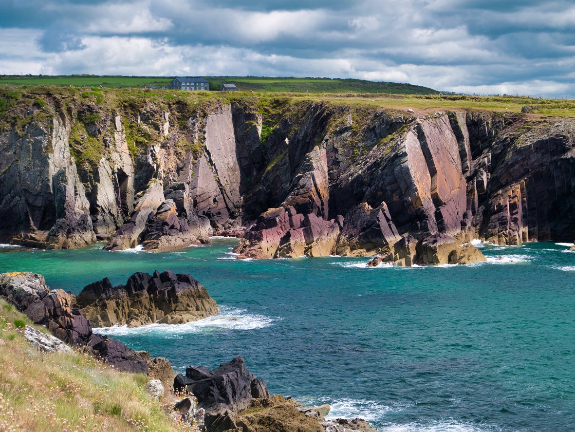 Leap across rocks along the Pembrokeshire coastal path on a coasteering trip
