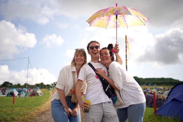 From left, Eef Berends, Stefan van der Berg and Ximena Lenzna, all from the Netherlands, queue for entry on the first day of the Glastonbury Festival (Yui Mok/PA)